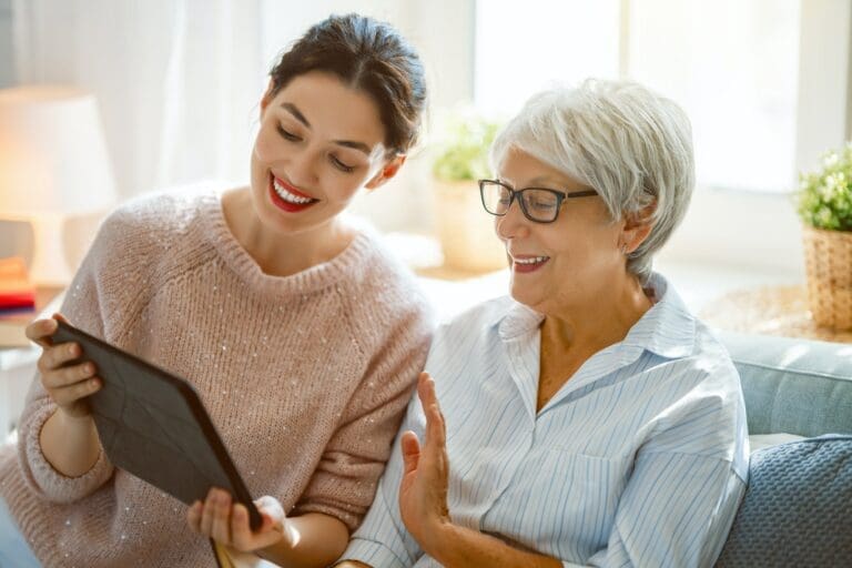 Frau erklärt Pflegeantrag am Tablet Digitaler Pflegeantrag