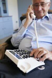 Pflegeperson spricht mit dem MDK am Telefon Digitaler Pflegeantrag